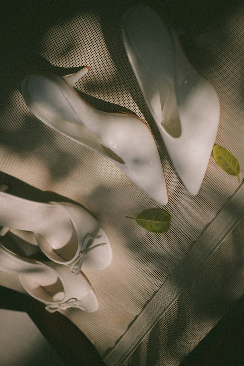 Three pairs of white shoes with leaves